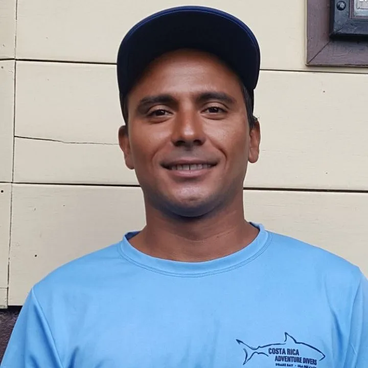 Portrait d'un homme souriant portant un t-shirt bleu et une casquette