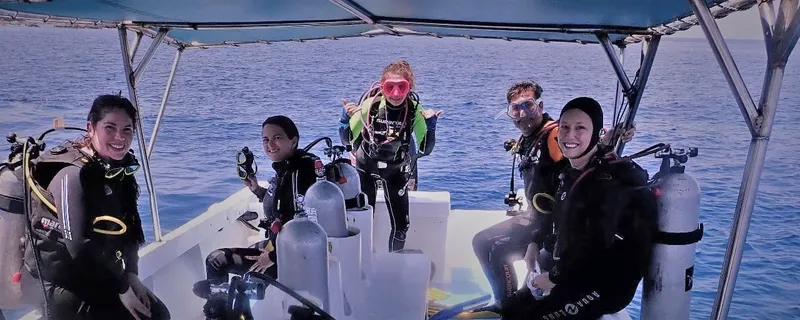 Plongeurs souriants sur un bateau avec leur équipement complet