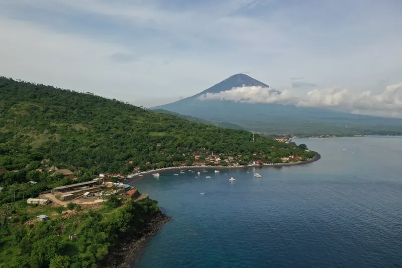 Vue aérienne d'une baie avec des bateaux et un volcan en arrière-plan
