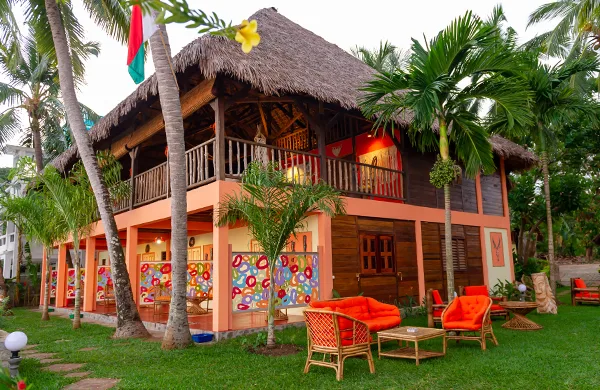 Bâtiment coloré avec toit de chaume et mobilier de jardin tropical