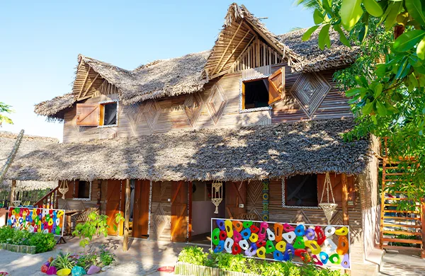 Bâtiment traditionnel avec toit de chaume et décorations colorées devant
