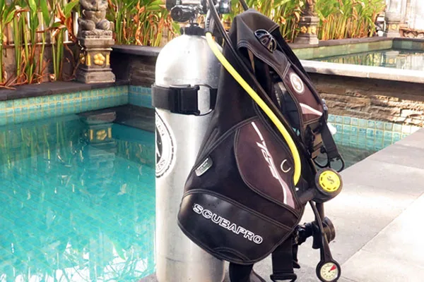 Equipement de plongée près d'une piscine turquoise avec végétation luxuriante
