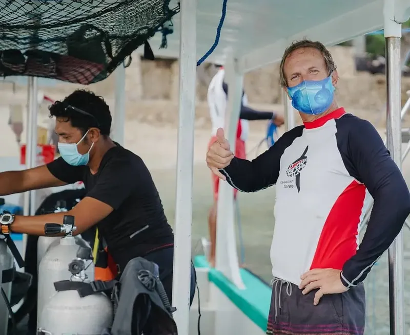 Deux personnes portant un masque et un gilet de sauvetage sur un bateau