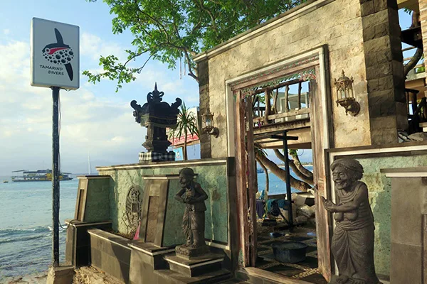 Façade d'un centre de plongée avec statue et vue sur la mer
