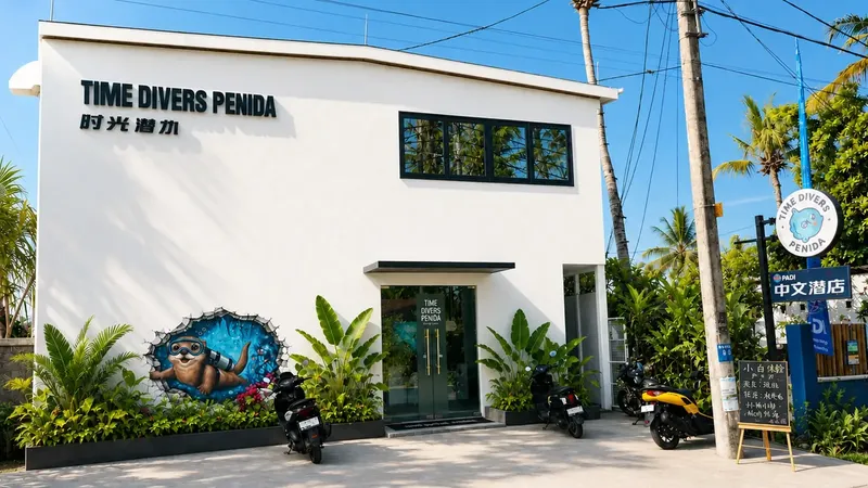 Façade blanche d'un centre de plongée avec des scooters et végétation