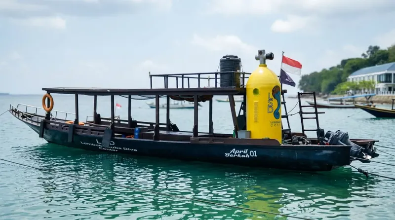 Bateau de plongée amarré avec des bouteilles et des drapeaux flottants