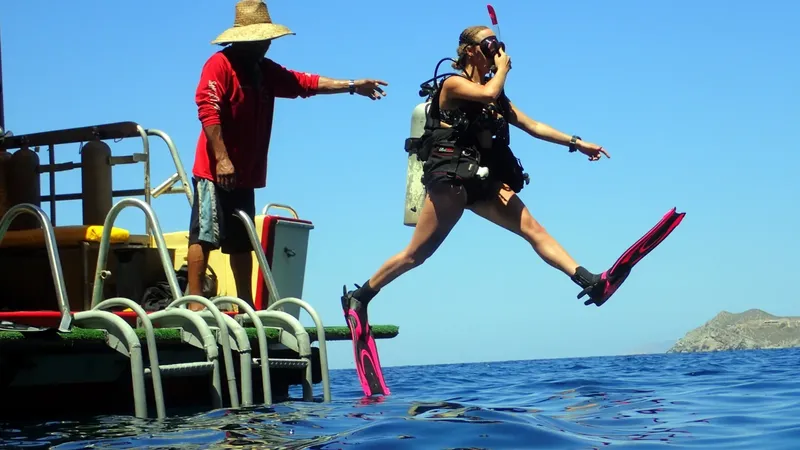 Plongeuse s'apprête à sauter d'un bateau avec son instructeur