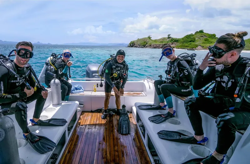 Plongée : groupe de personnes équipées sur un bateau en mer