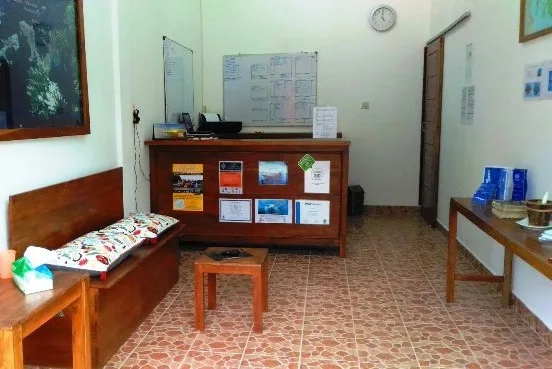 Salle d'accueil avec comptoir, tableaux, banc et sol carrelé