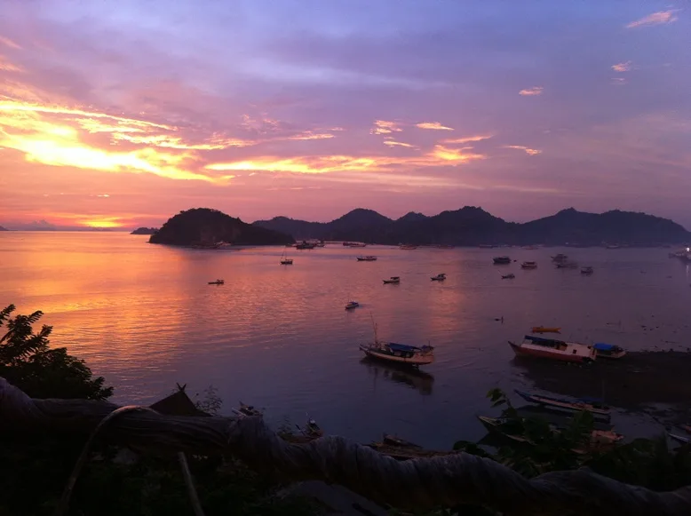 Coucher de soleil sur une baie avec des bateaux amarrés au large