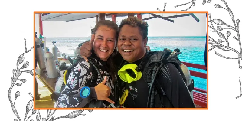 Deux plongeurs souriants posent sur un bateau avec leur équipement