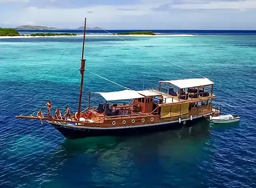 Bateau de plongée en mer turquoise avec des personnes à bord