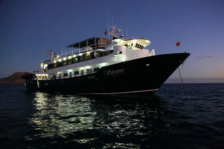 Grand bateau de plongée illuminé la nuit sur une mer calme