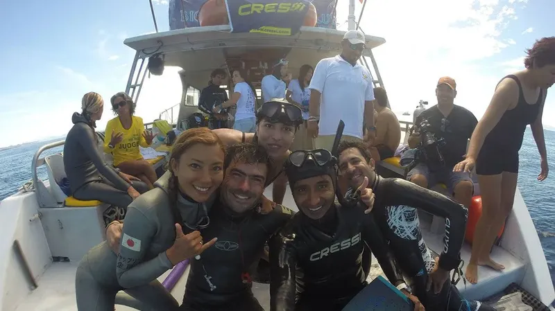 Groupe de plongeurs souriants sur un bateau en mer ensoleillée