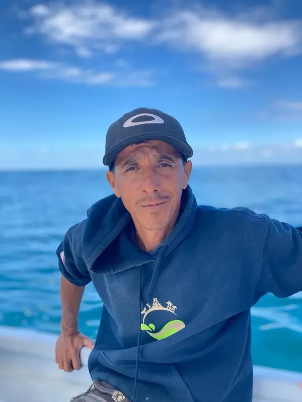 Portrait d'un homme souriant sur un bateau avec la mer en arrière-plan