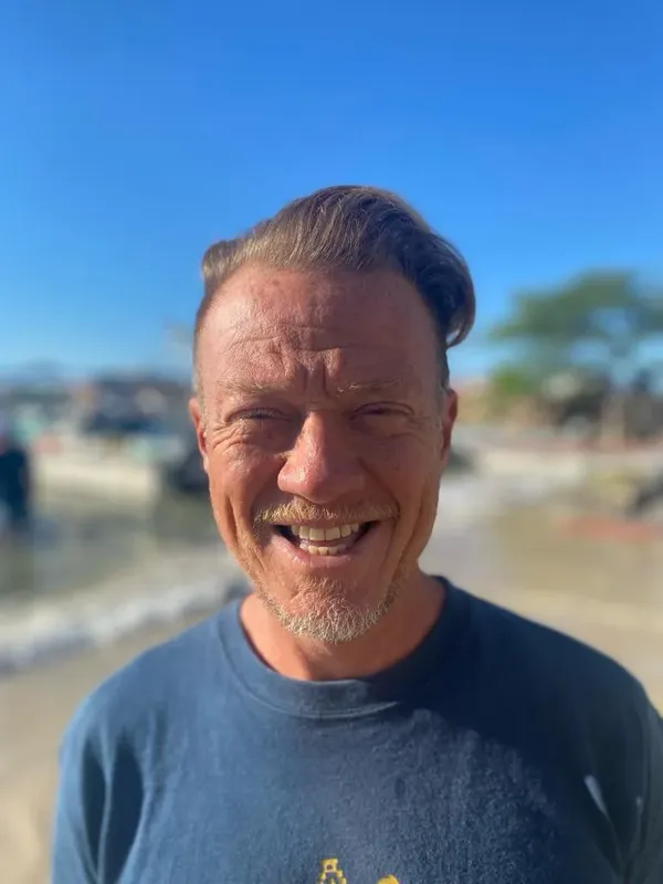 Homme souriant, visage en gros plan, ciel bleu en arrière-plan
