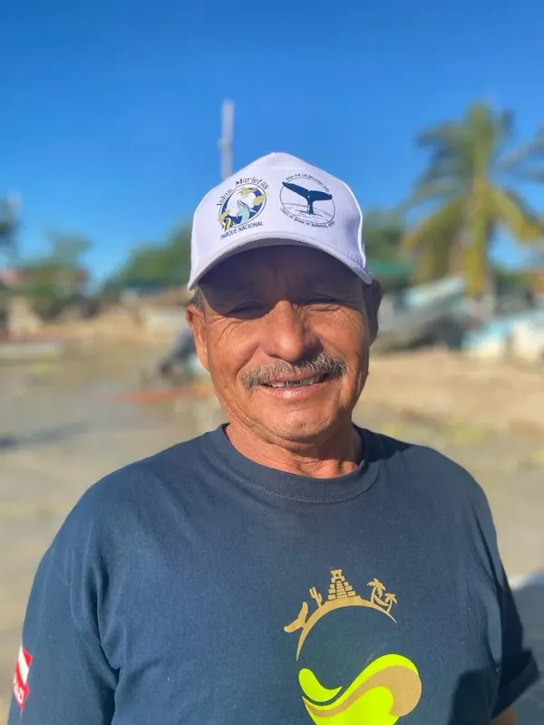 Homme souriant portant une casquette et un t-shirt avec un motif