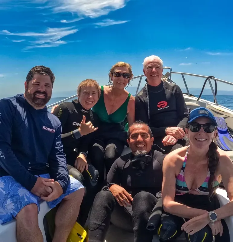 Groupe de plongeurs souriants à bord d'un bateau en mer