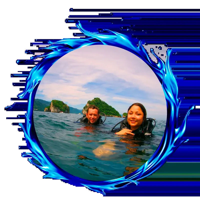 Deux plongeurs souriants émergent dans une eau turquoise avec paysage