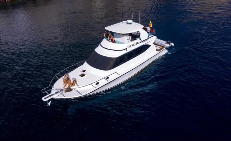 Bateau de plongée blanc avec des personnes à bord en mer calme