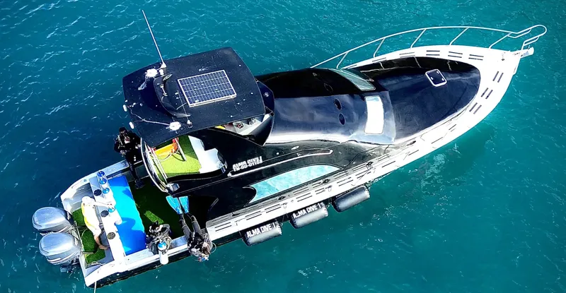 Bateau de plongée noir et blanc sur mer turquoise avec équipement
