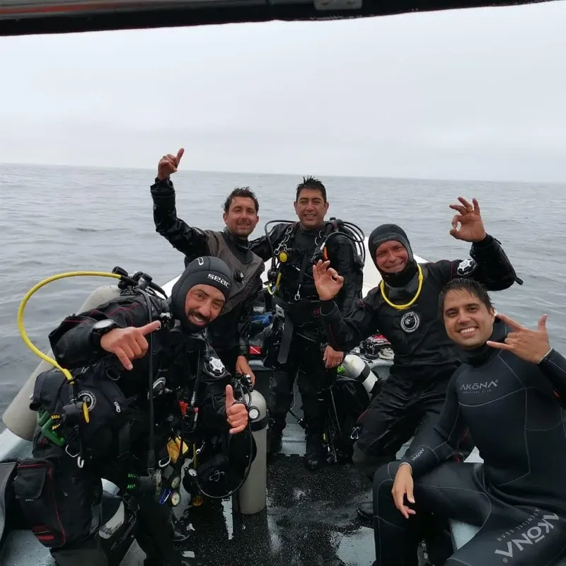 Groupe de plongeurs souriants à bord d'un bateau semi-rigide en mer