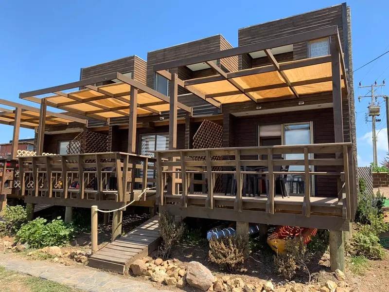 Bâtiment en bois avec terrasse et végétation au premier plan