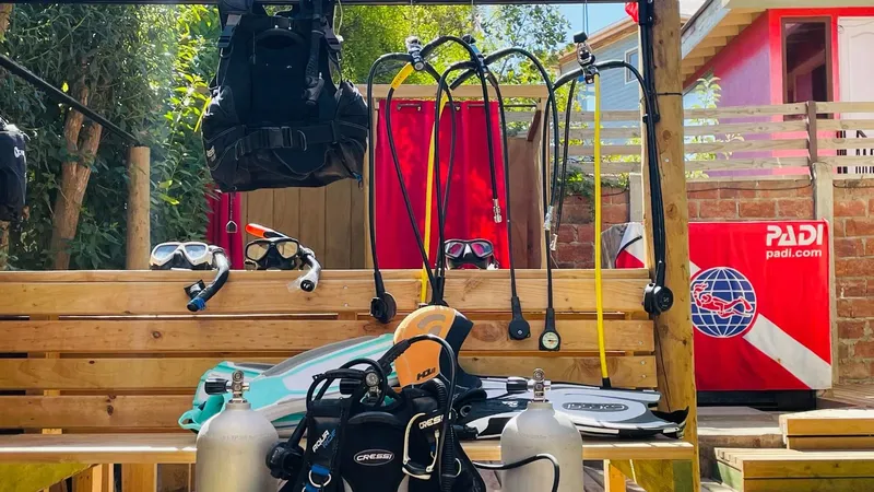 Equipement de plongée complet suspendu et posé sur des bancs en bois
