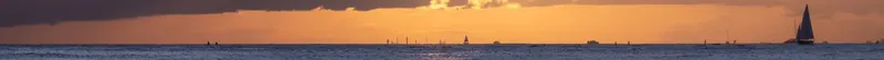Lever de soleil sur la mer avec des voiliers à l'horizon