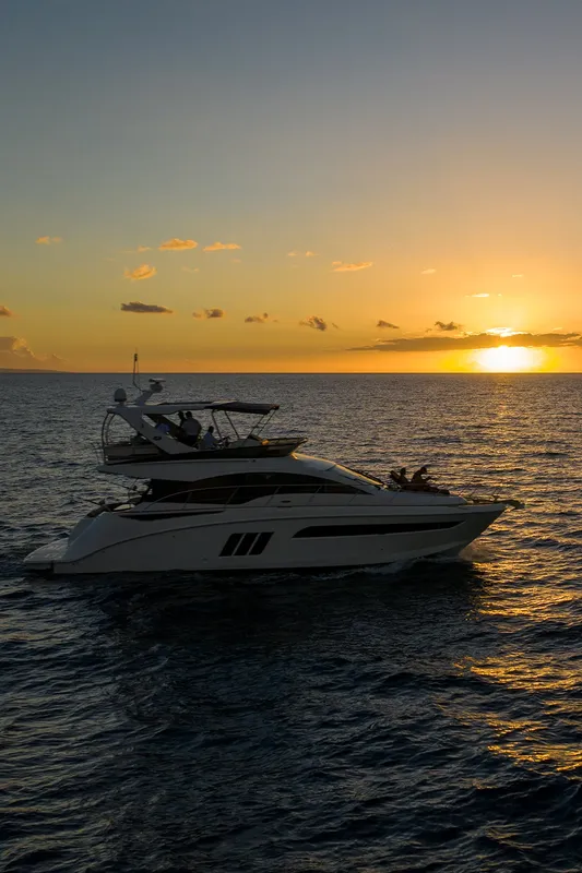 Grand yacht blanc navigue sur une mer calme au coucher du soleil