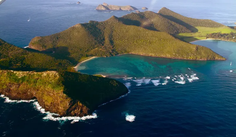 Vue aérienne d'une côte rocheuse avec une plage et des eaux turquoise