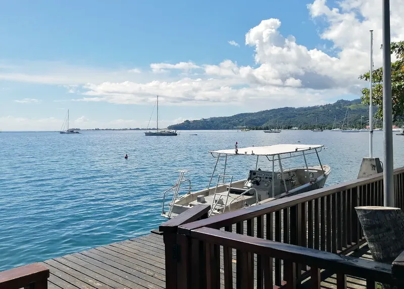 Vue sur la mer avec un bateau amarré et des personnes