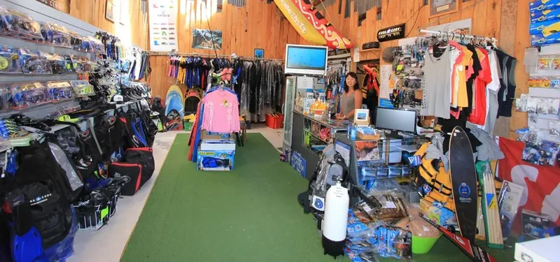 Intérieur d'un centre de plongée avec matériel, vêtements et comptoir d'accueil