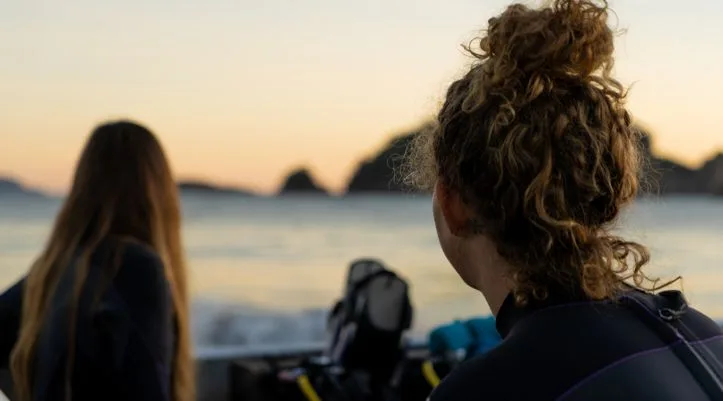 Deux plongeuses regardent l'horizon depuis un bateau en mer