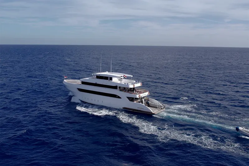 Grand bateau de croisière blanc navigue sur une mer bleue calme