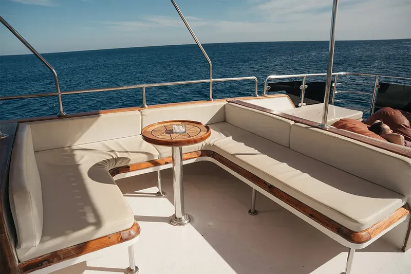Bateau de plongée avec assises blanches et table ronde en bois