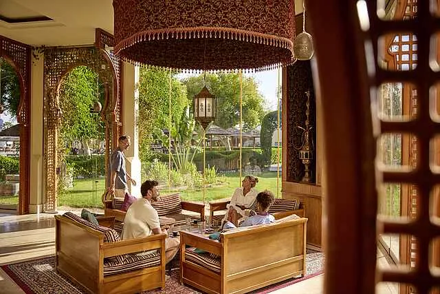 Quatre personnes discutent dans un salon décoré de style oriental