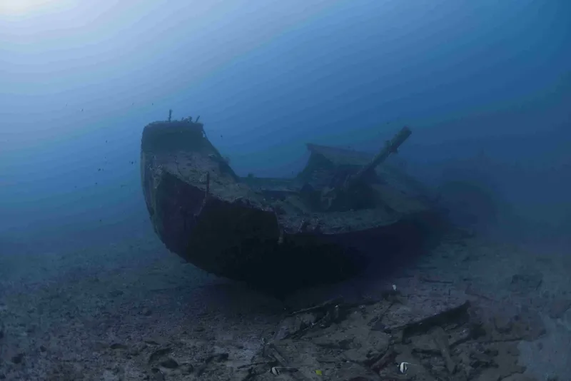 Épave de bateau reposant sur le fond marin sableux et clair