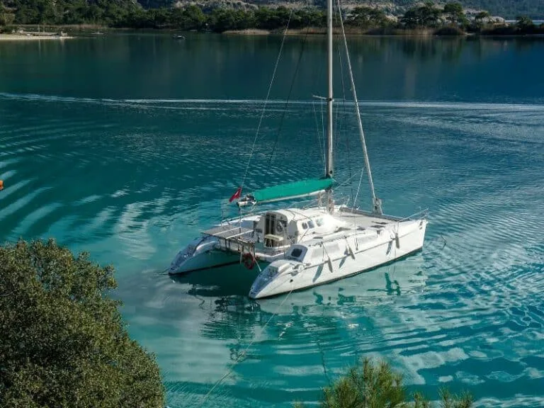 Catamaran blanc amarré dans une baie turquoise ensoleillée