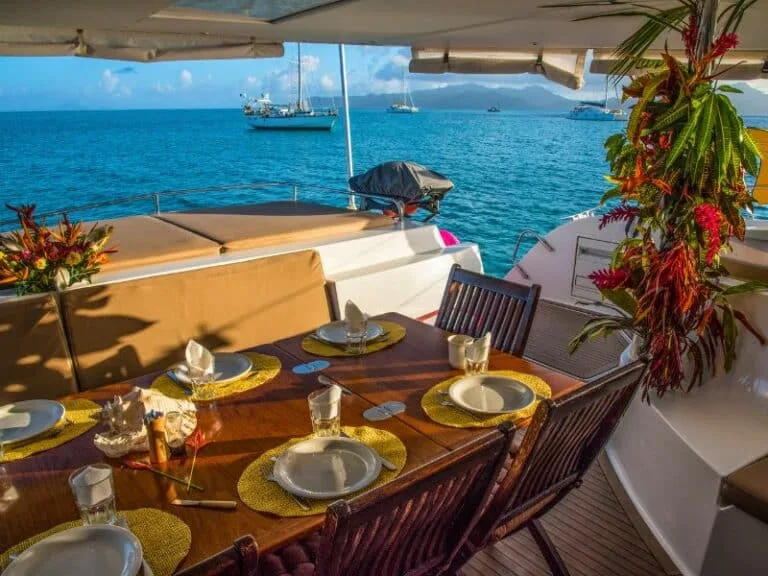 Table dressée sur un catamaran en mer, vue sur l'océan