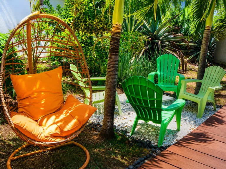 Espace détente extérieur avec fauteuil suspendu et chaises colorées