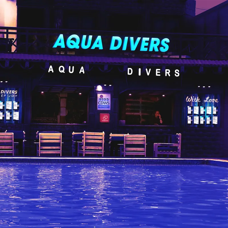 Façade d'un centre de plongée illuminée avec une piscine au premier plan