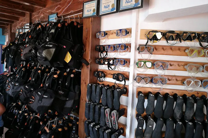 Rangées de gilets de sauvetage, masques et chaussons de plongée alignés
