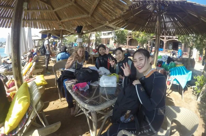 Groupe de plongeuses souriantes se reposent à l'ombre sur une terrasse
