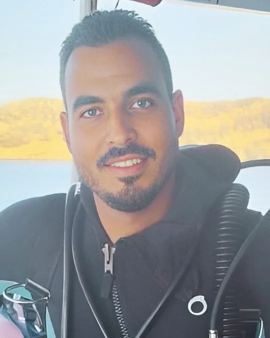 Portrait d'un homme souriant en combinaison de plongée sur un bateau