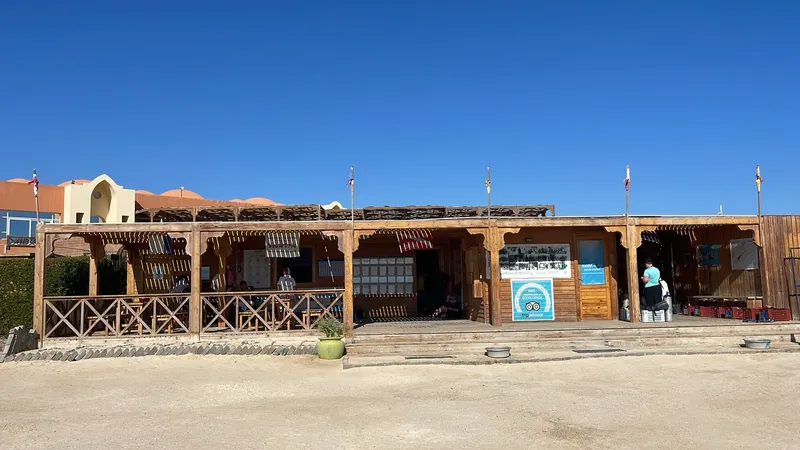 Façade d'un centre de plongée avec des personnes et des ombrages