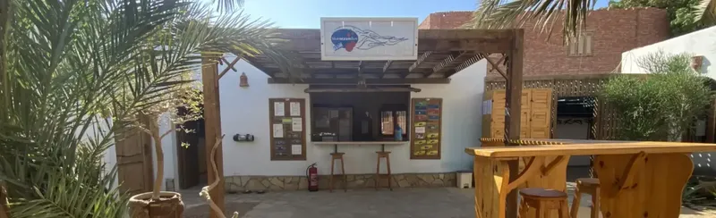 Devanture d'un centre de plongée avec une structure en bois et végétation