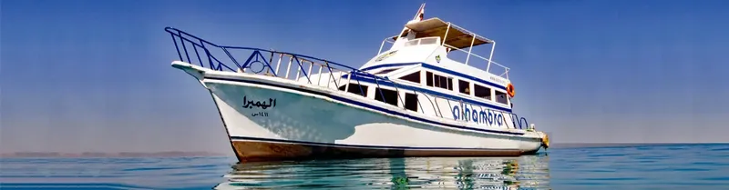 Grand bateau de plongée blanc et bleu sur une mer calme