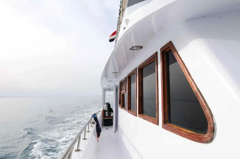 Vue latérale d'un bateau de plongée blanc naviguant sur une mer calme