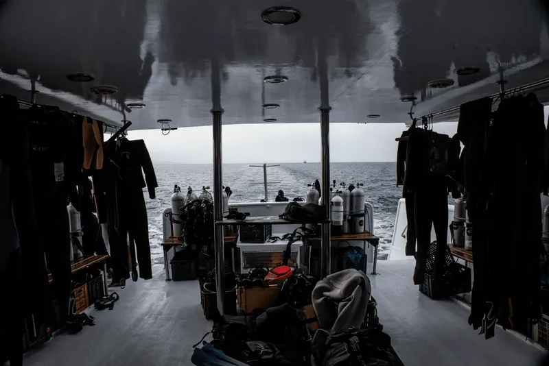 Intérieur d'un bateau de plongée avec équipement et plongeurs à l'arrière